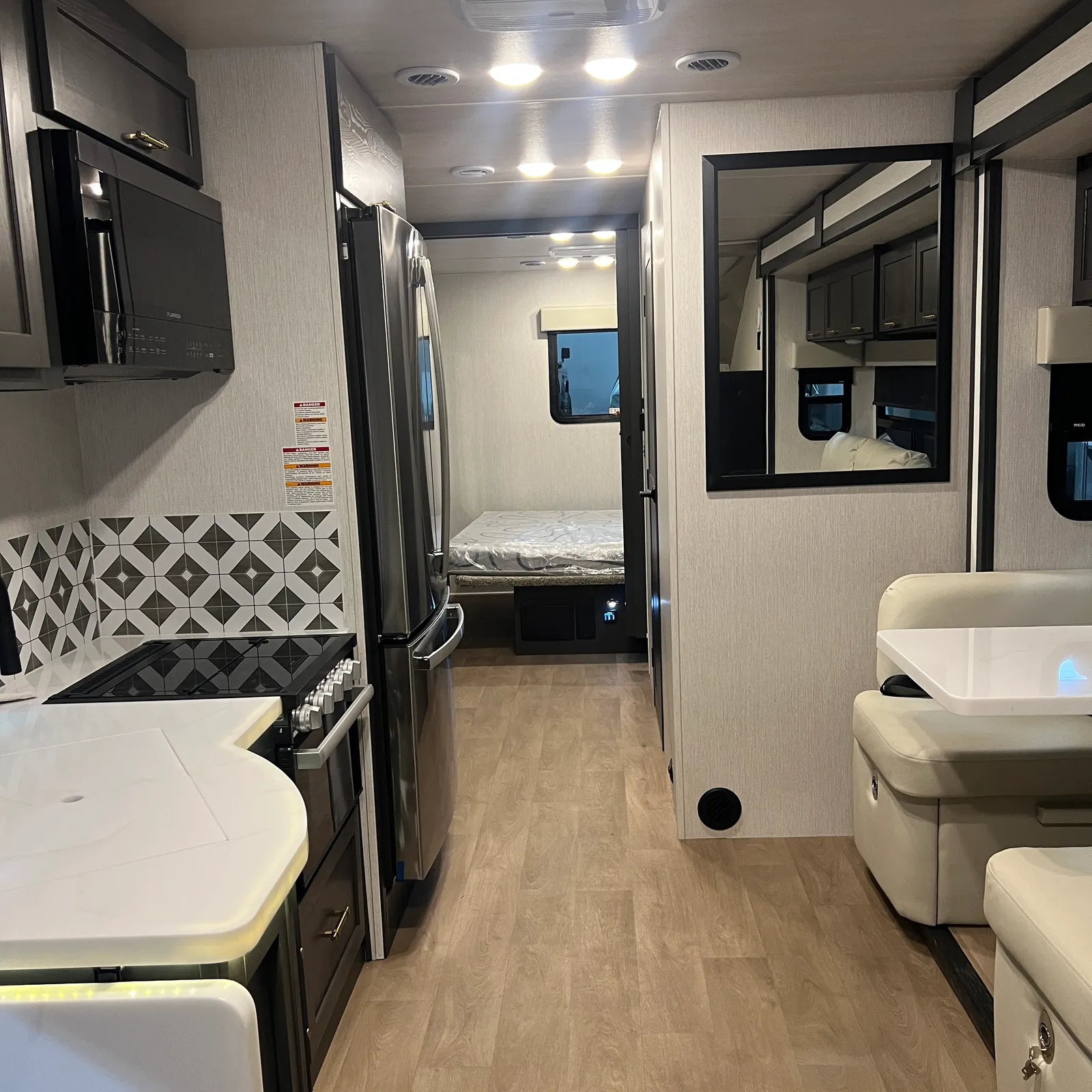 2027 Nexus Ghost 36DS Super C motorhome, galley kitchen with refrigerator, stove, and microwave adjacent to bedroom and bathroom