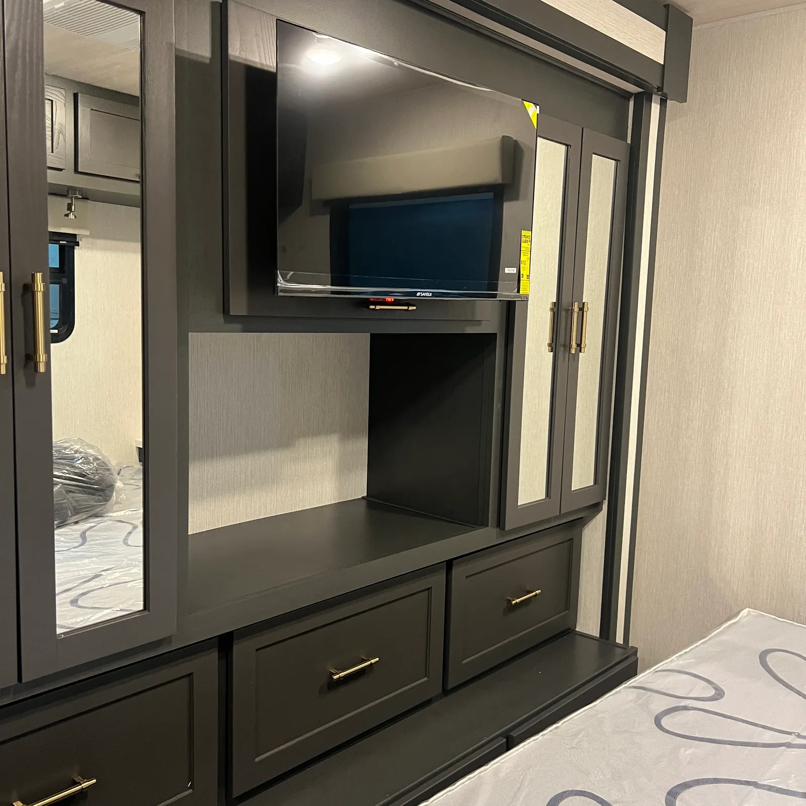 2027 Nexus Ghost 36DS Super C motorhome, bedroom with built-in entertainment center and mirrored wardrobe