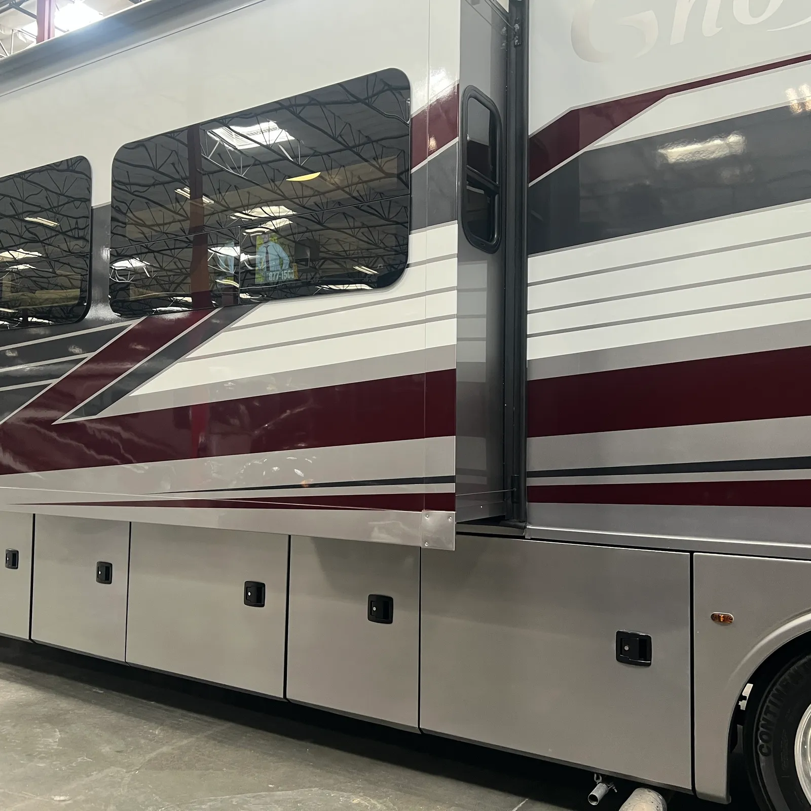 2027 Nexus Ghost 36DS Super C motorhome, side profile of motorhome with windows, door, and storage compartments