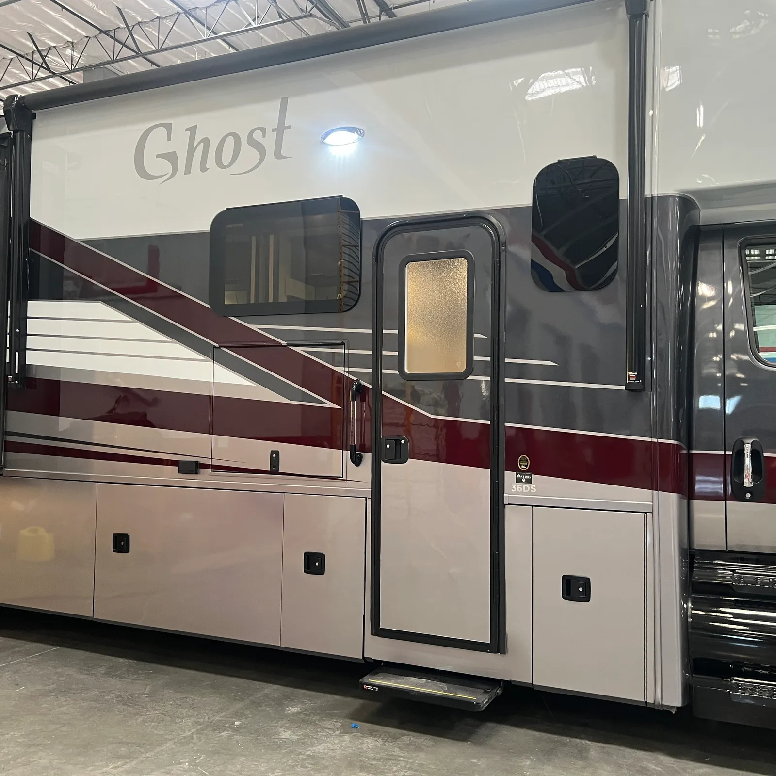 2027 Nexus Ghost 36DS Super C motorhome, motorhome exterior showing white and burgundy side with entry door and windows