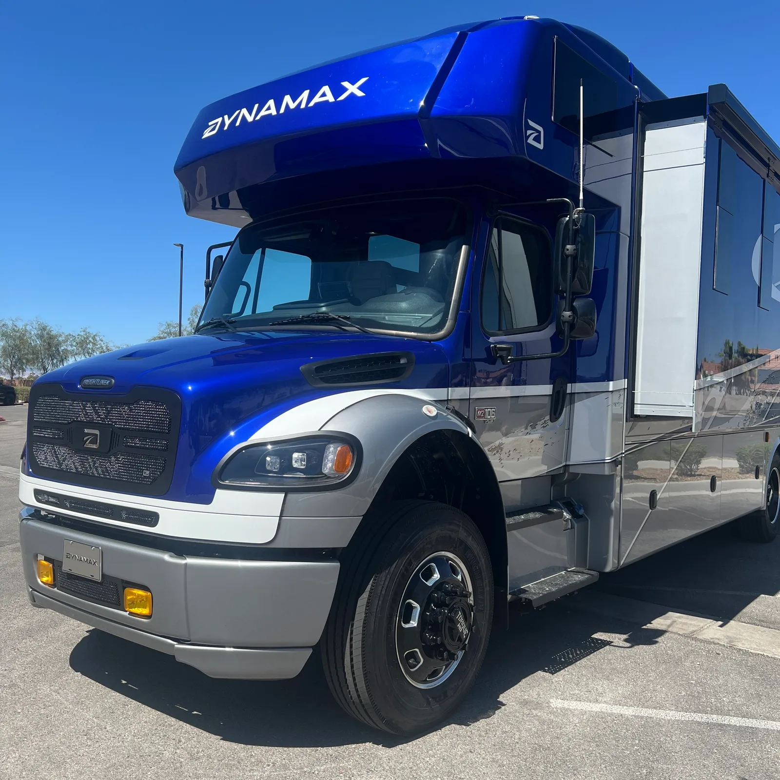 2027 Dynamax Corp DX3 32KD Super C motorhome, blue and white super c motorhome with open entry door