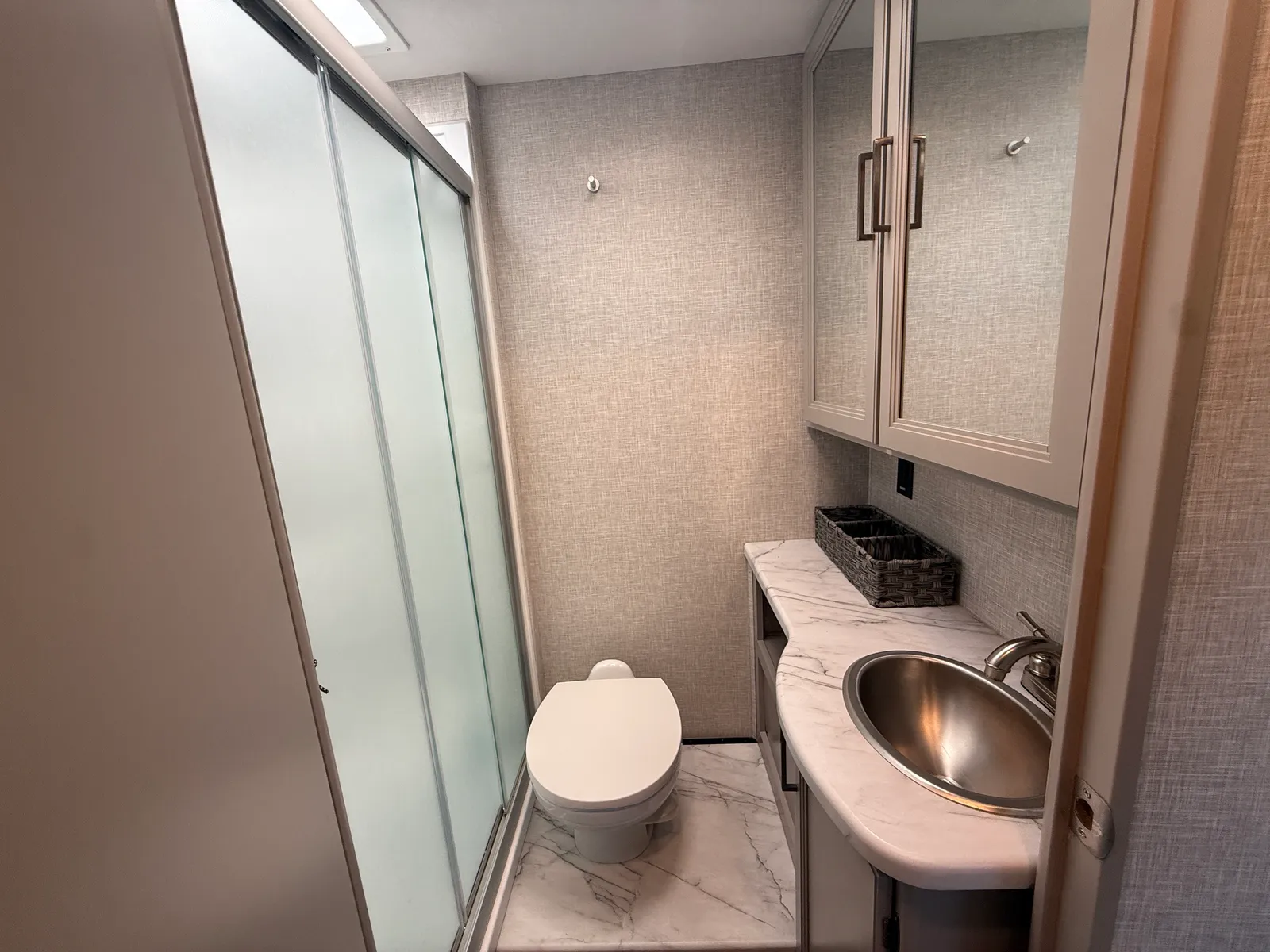 2023 Thor Motor Coach Geneva Class C motorhome, bathroom with toilet, sink, shower enclosure and storage cabinet