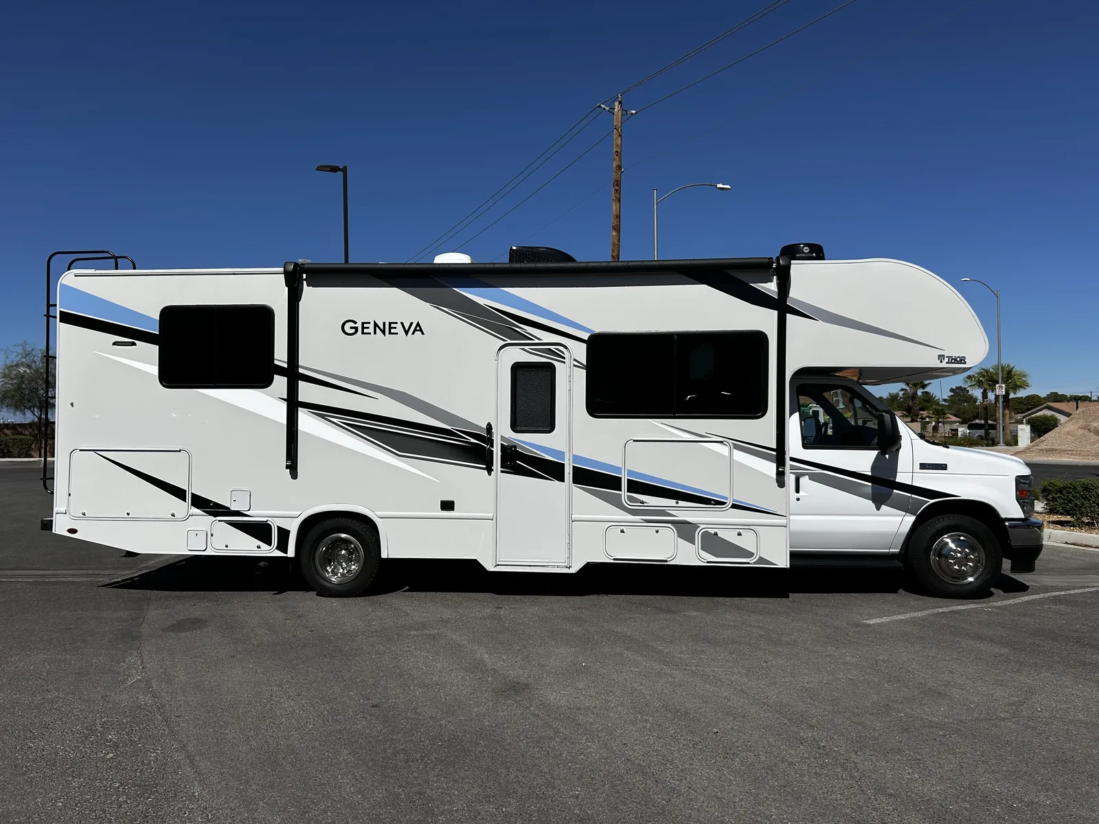 2023 Thor Motor Coach Geneva Class C motorhome, white motorhome with blue and black striping parked in lot