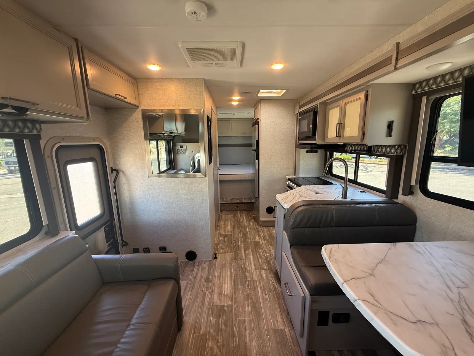 2023 Thor Motor Coach Geneva Class C motorhome, motorhome interior with bunk beds, seating area, and galley forward
