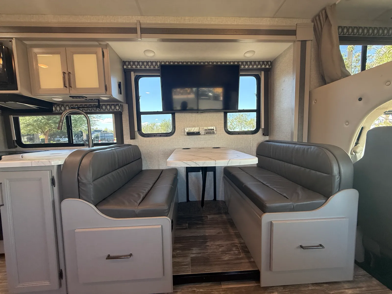 2023 Thor Motor Coach Geneva Class C motorhome, living area with facing leather bench seats and dinette table