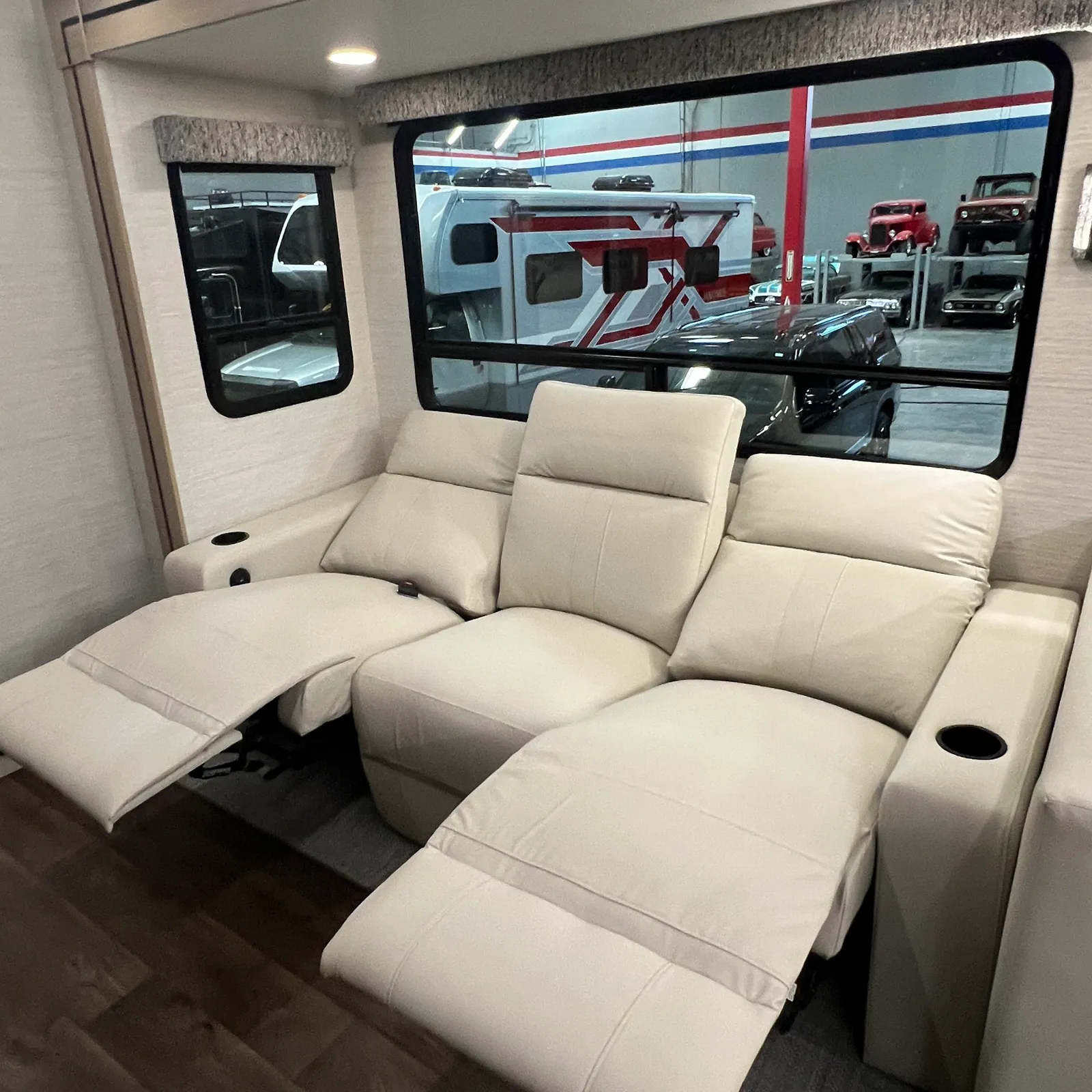 2027 Dynamax Corp Europa S 37CA Super C motorhome, cream leather reclining seating with cup holders in living area