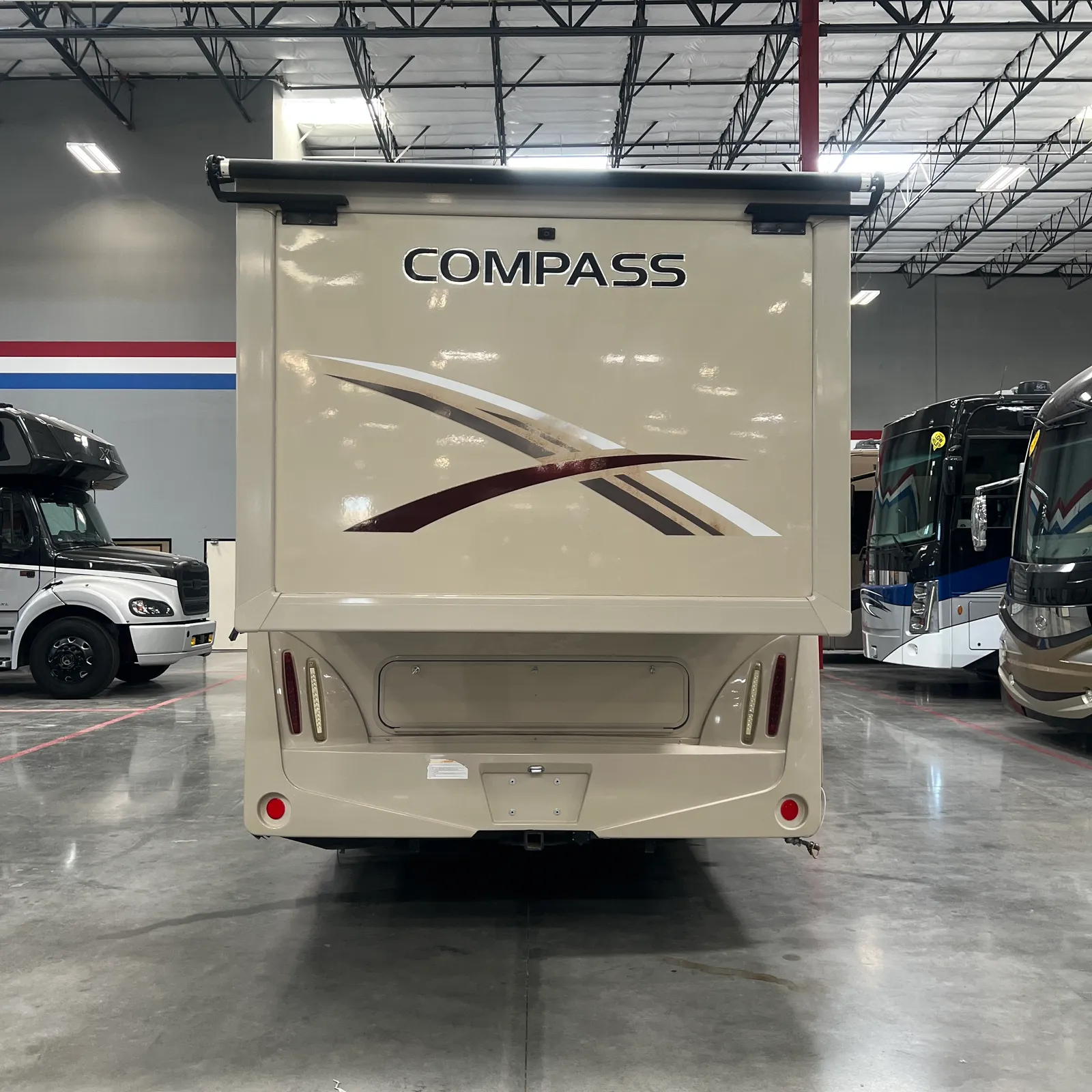 2018 Thor Motor Coach Compass 23TR Class C motorhome, rear view of cream colored motorhome with compass branding and maroon accent stripe