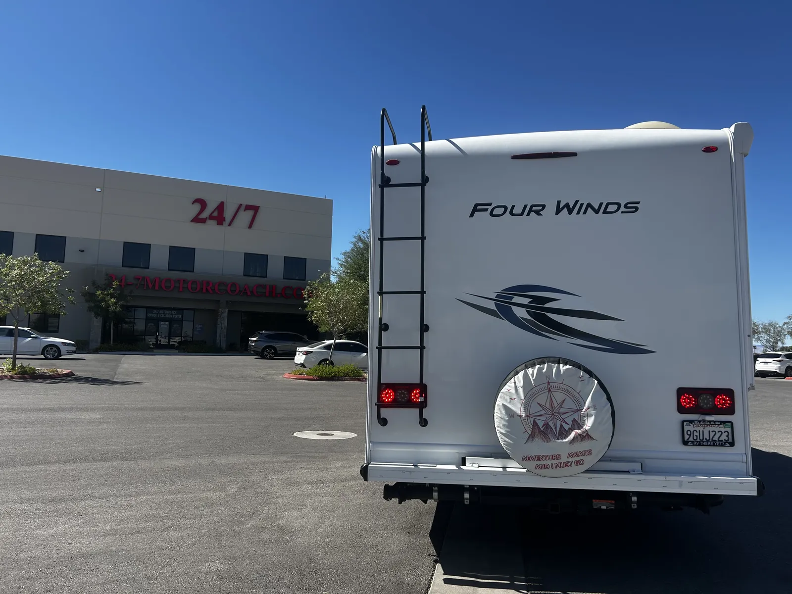 2023 Thor Motor Coach Four Winds Super C motorhome, rear of white motorhome with ladder, spare tire, and taillights