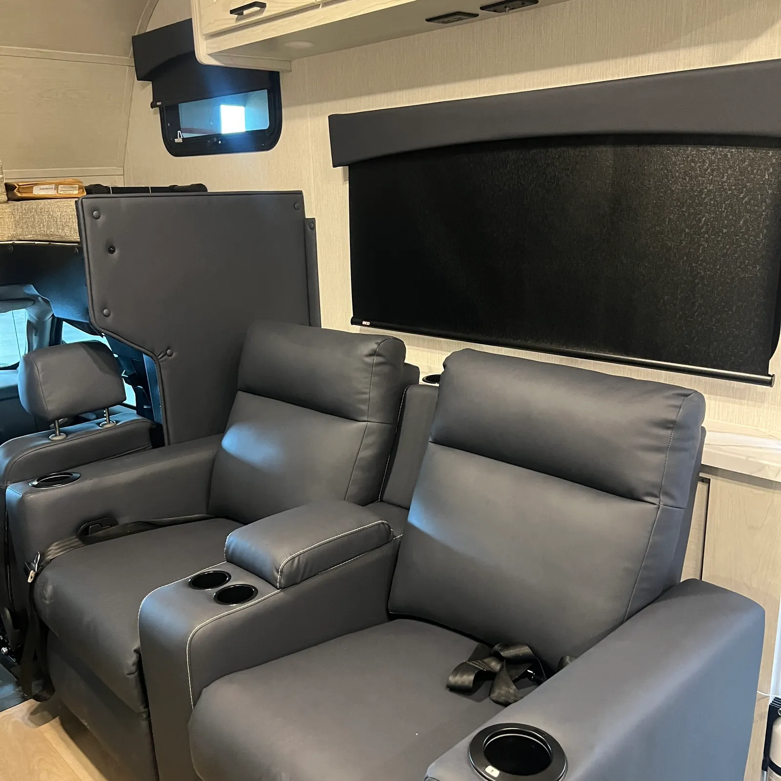 2027 Nexus Rebel AIR 34R Super C motorhome, living area with gray leather recliners, overhead tv, and window with shade