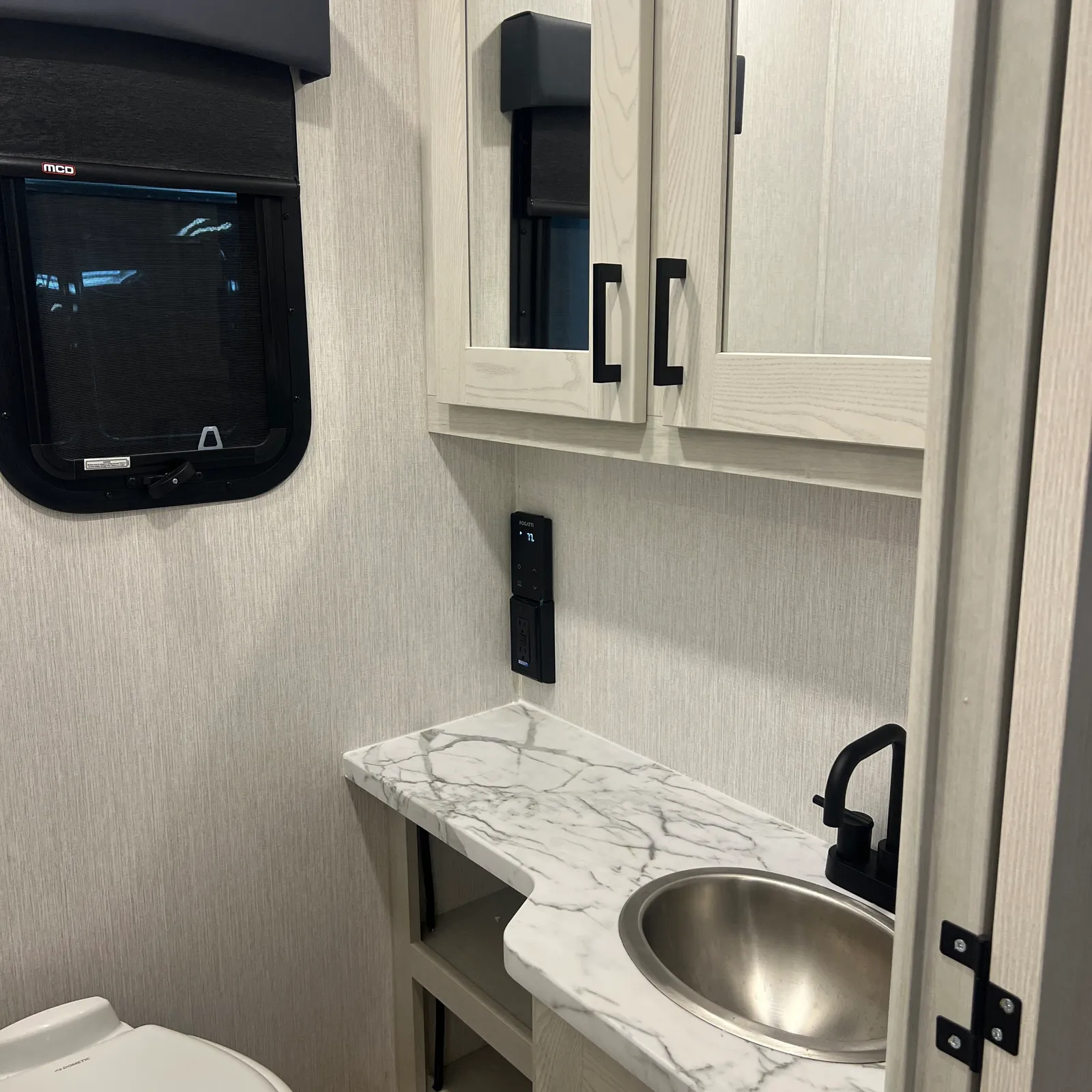 2027 Nexus Rebel AIR 34R Super C motorhome, bathroom with marble countertop, stainless steel sink, and storage cabinets