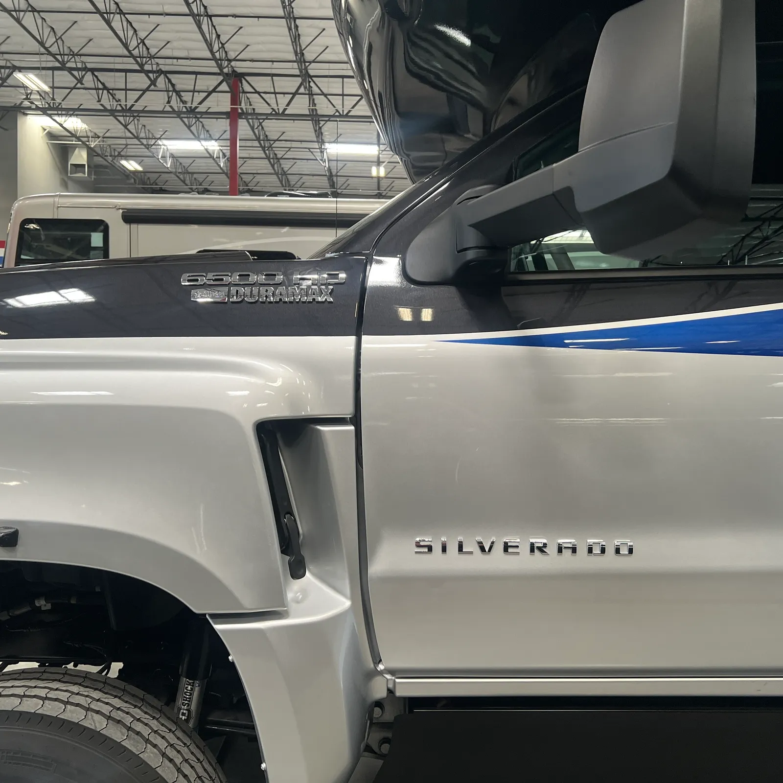 2027 Nexus Rebel AIR 34R Super C motorhome, white motorhome with blue stripe and truck cab detail