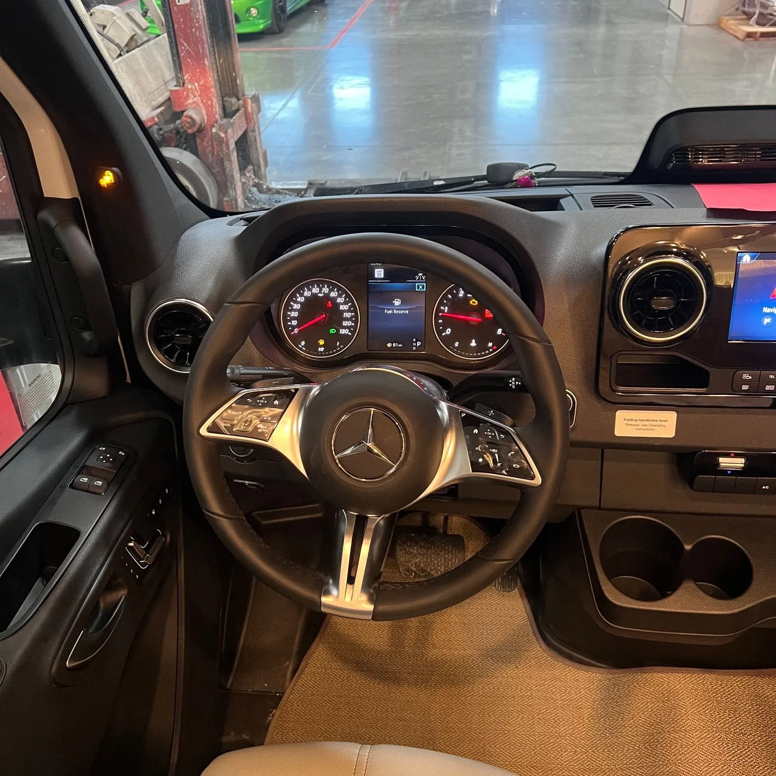 2026 Thor Delano 24XL Class C motorhome, driver's area with steering wheel, instrument cluster, and infotainment display