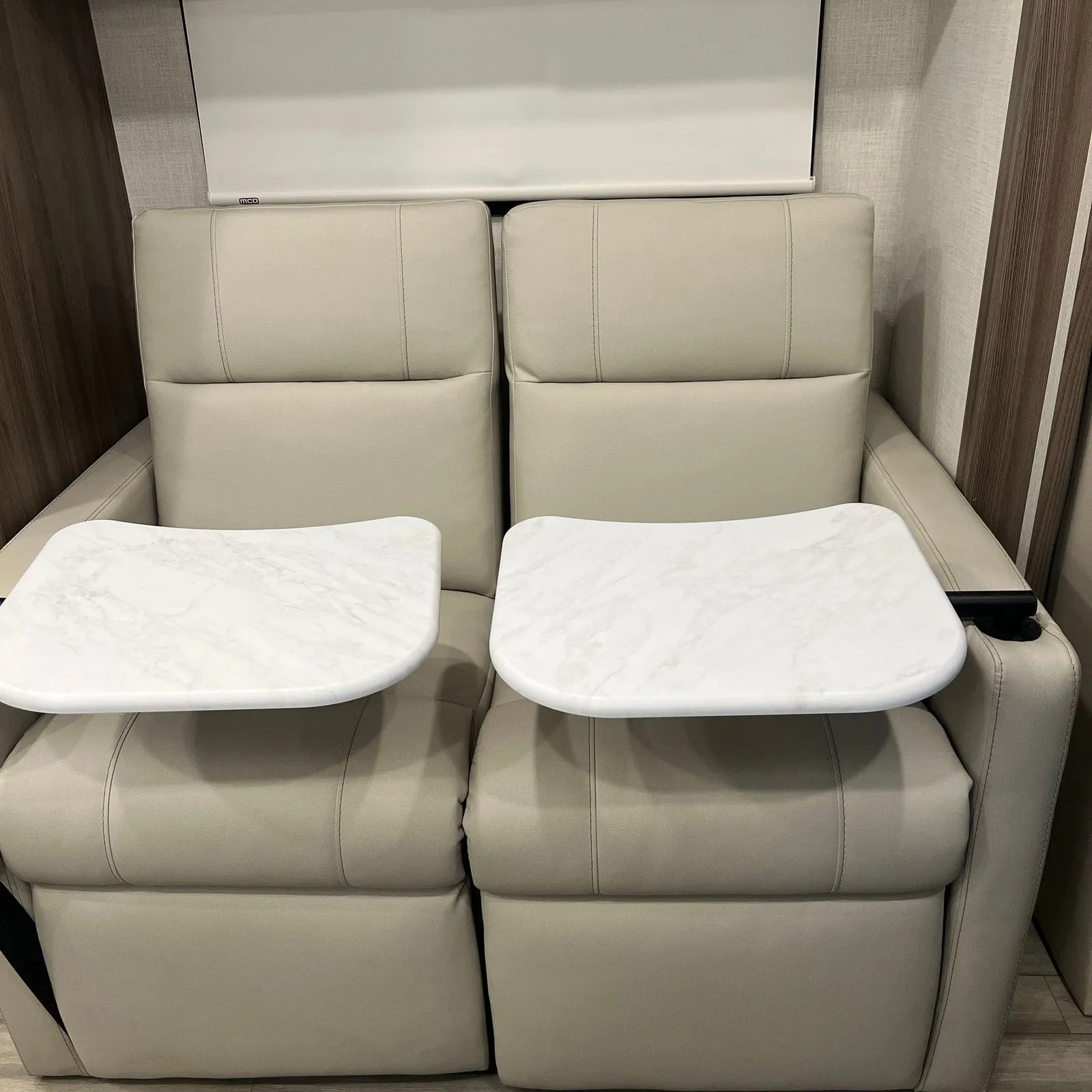 2026 Thor Delano 24XL Class C motorhome, cream leather recliners with white tray tables and overhead storage