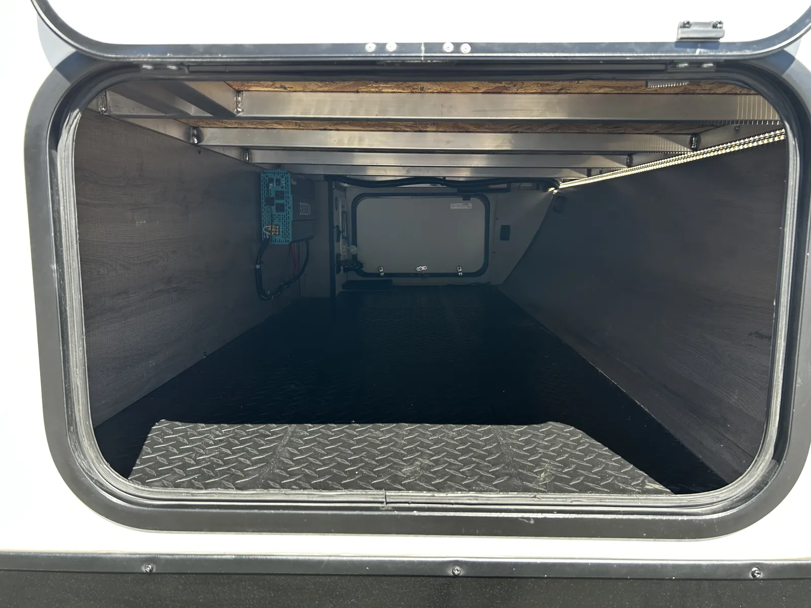 2024 Grand Design Imagine Xls 22MLE Travel Trailer motorhome, open storage bay with metal diamond plate floor and interior components