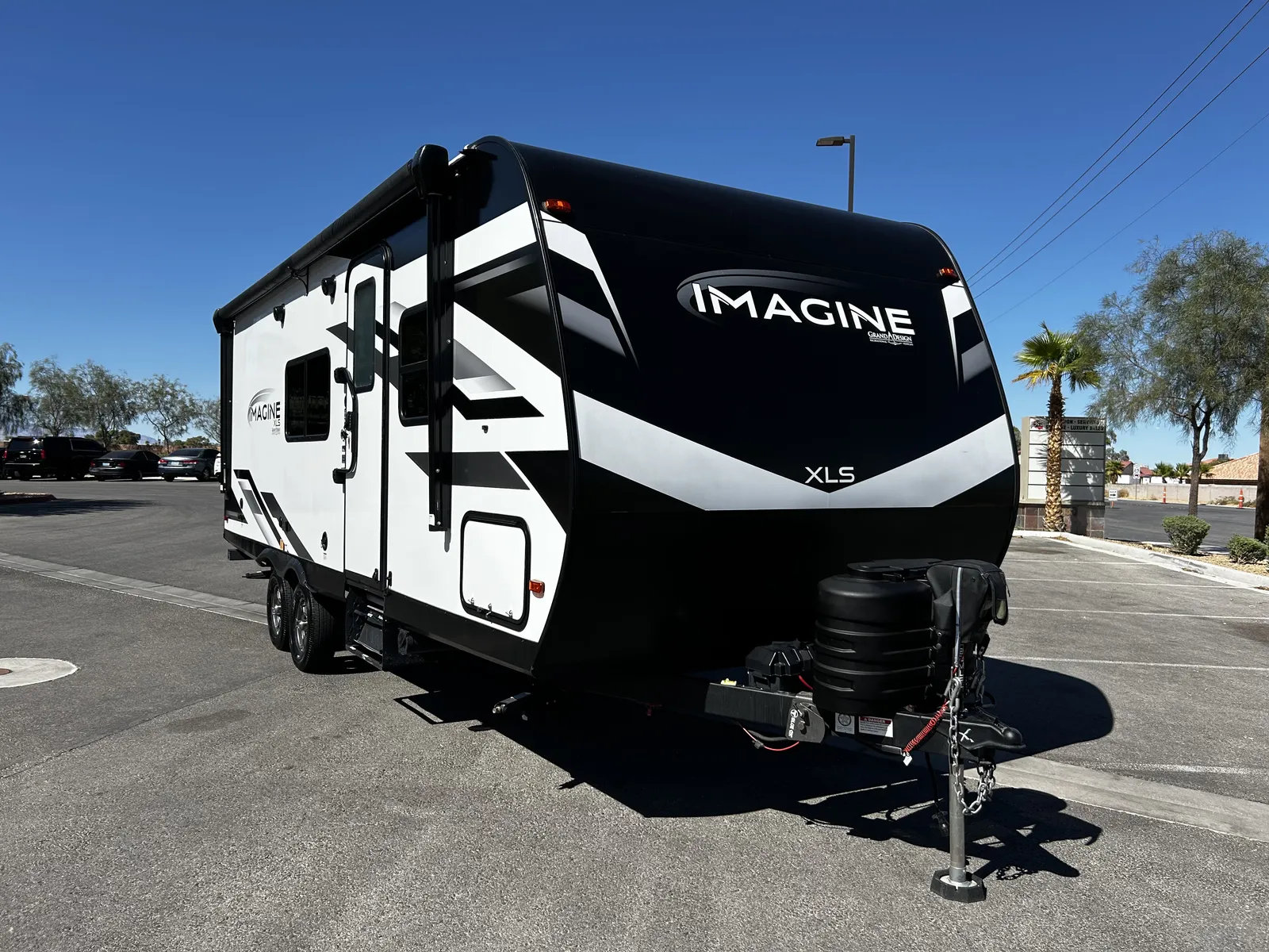 2024 Grand Design Imagine Xls 22MLE Travel Trailer motorhome, rear view of black and white travel trailer with storage compartments