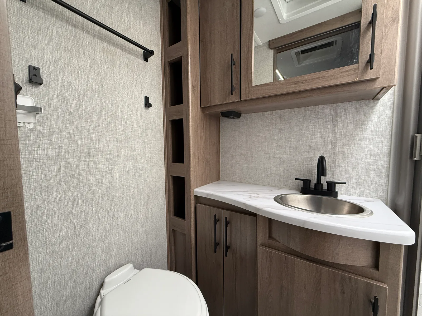 2024 Grand Design Imagine Xls 22MLE Travel Trailer motorhome, bathroom with toilet, sink, cabinet with mirror, and storage