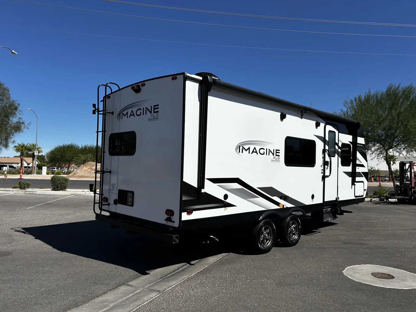 2024 Grand Design Imagine Xls 22MLE Travel Trailer motorhome, white travel trailer with black trim and extended awning