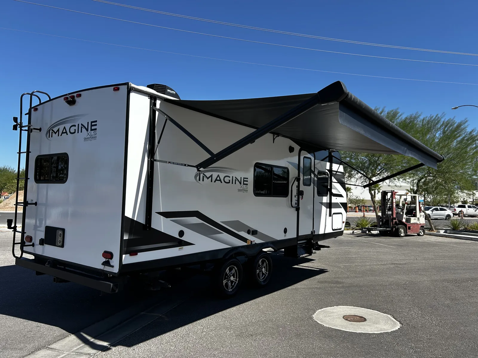 2024 Grand Design Imagine Xls 22MLE Travel Trailer motorhome, white travel trailer with extended awning in dealer lot