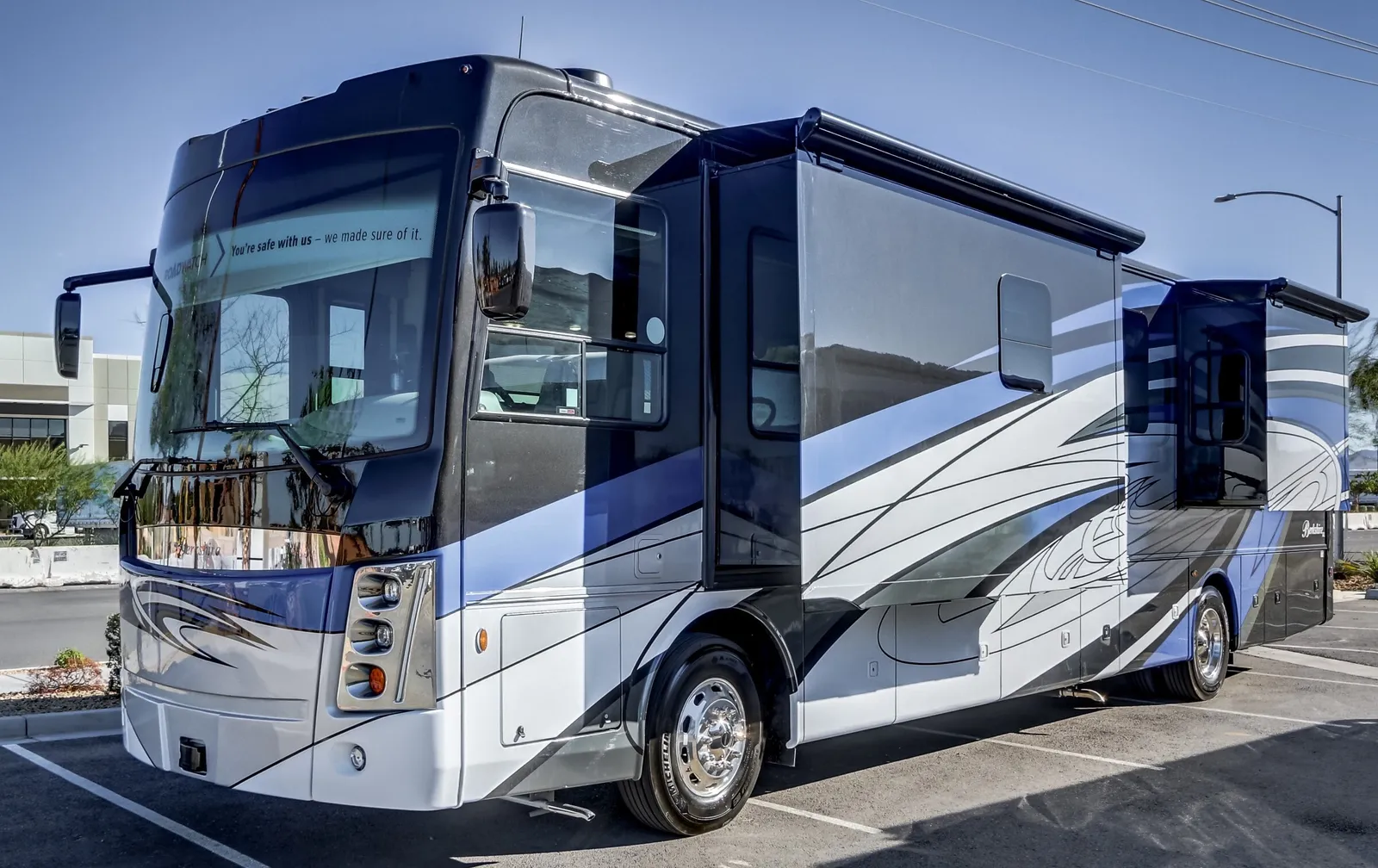 2024 Forest River Berkshire XL 40E Class A Diesel Pusher motorhome, blue and white motorhome with extended slide-out and awning deployed
