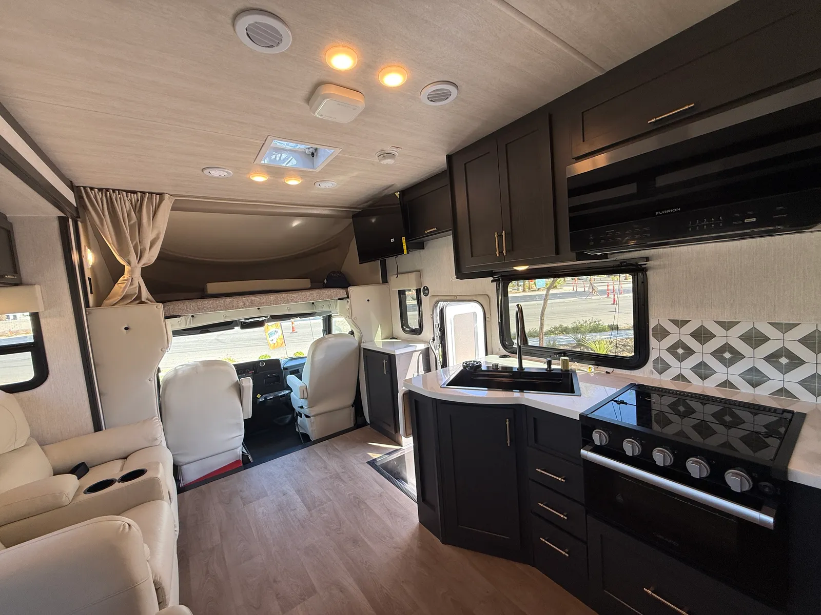 2027 Nexus Ghost 36DS Super C motorhome, open concept living area with kitchen, dinette seating, and cockpit view
