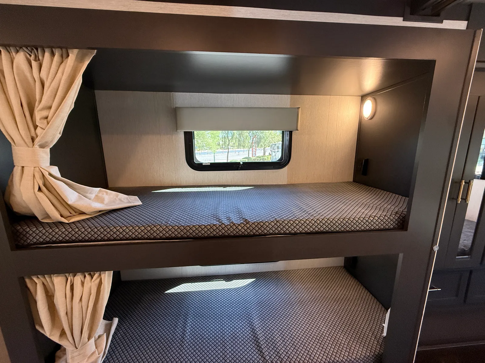 2027 Nexus Ghost 36DS Super C motorhome, dual bunk beds with windows and beige curtains