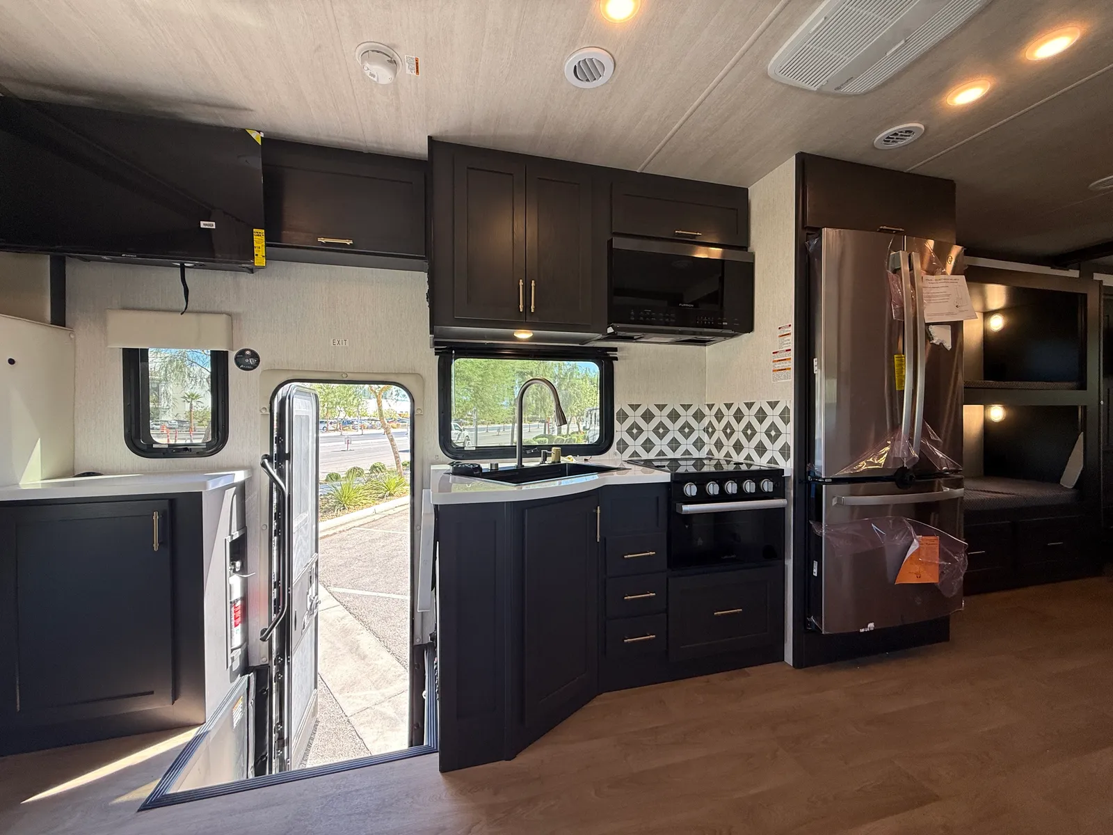 2027 Nexus Ghost 36DS Super C motorhome, kitchen with dark cabinetry, stainless steel appliances, and windows