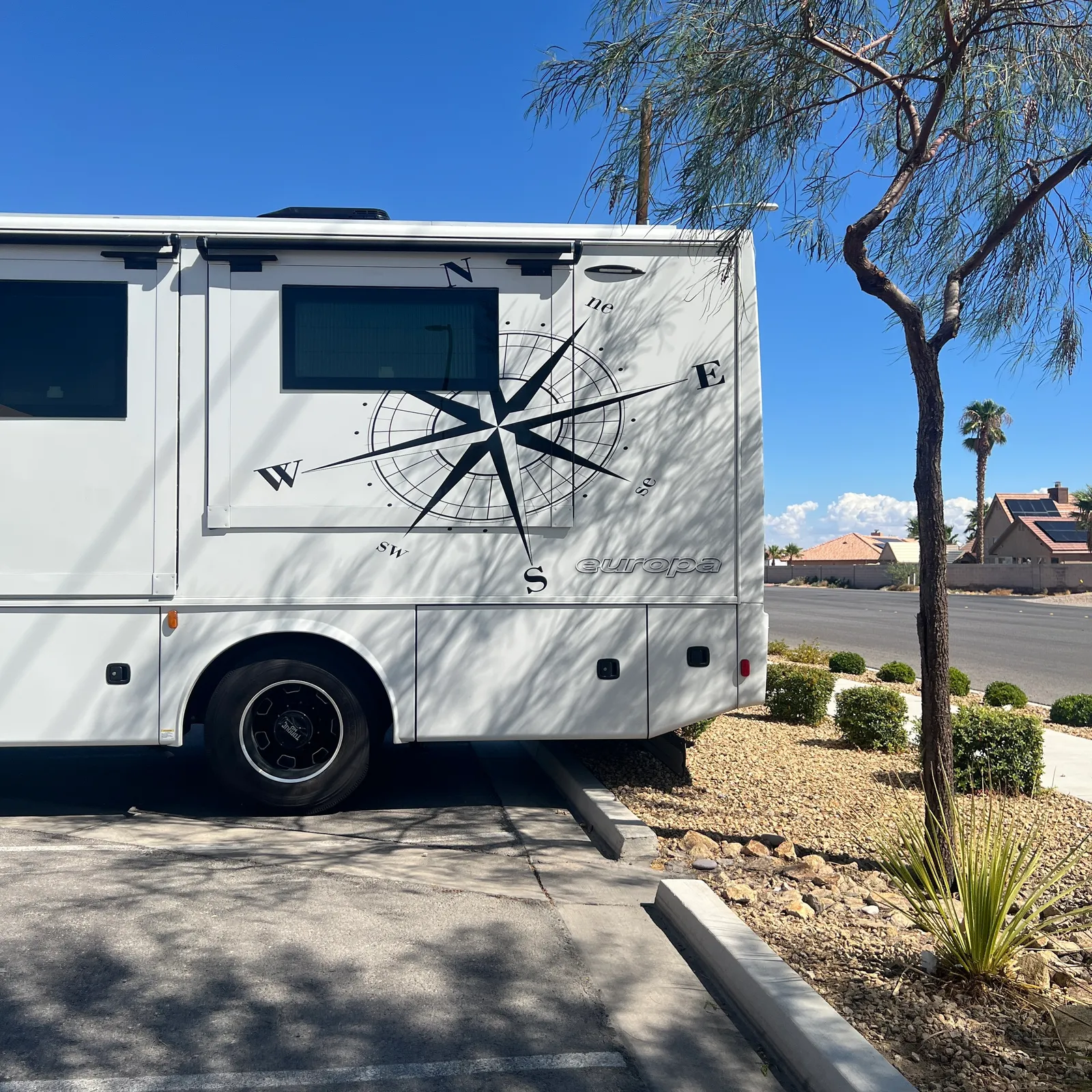 2027 Dynamax Corp Europa 31SS Super C motorhome, white motorhome with compass rose graphic on side