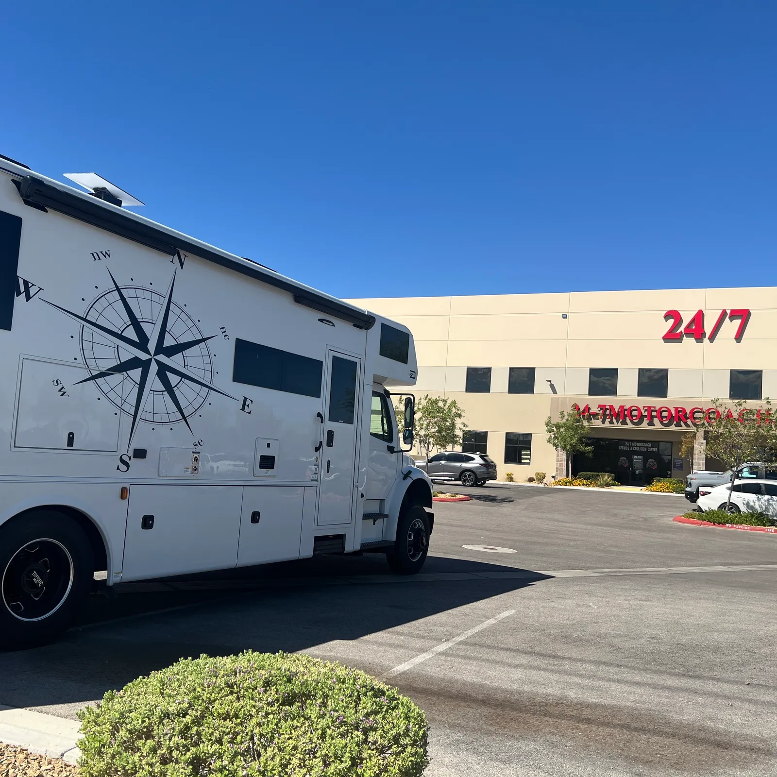 2027 Dynamax Corp Europa 31SS Super C motorhome, white motorhome with compass rose graphics parked at dealership